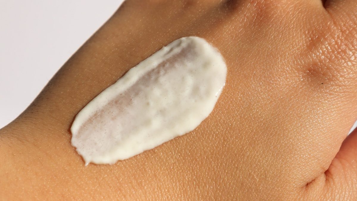 Mineral sunscreen swiped on the back of a hand in natural light.